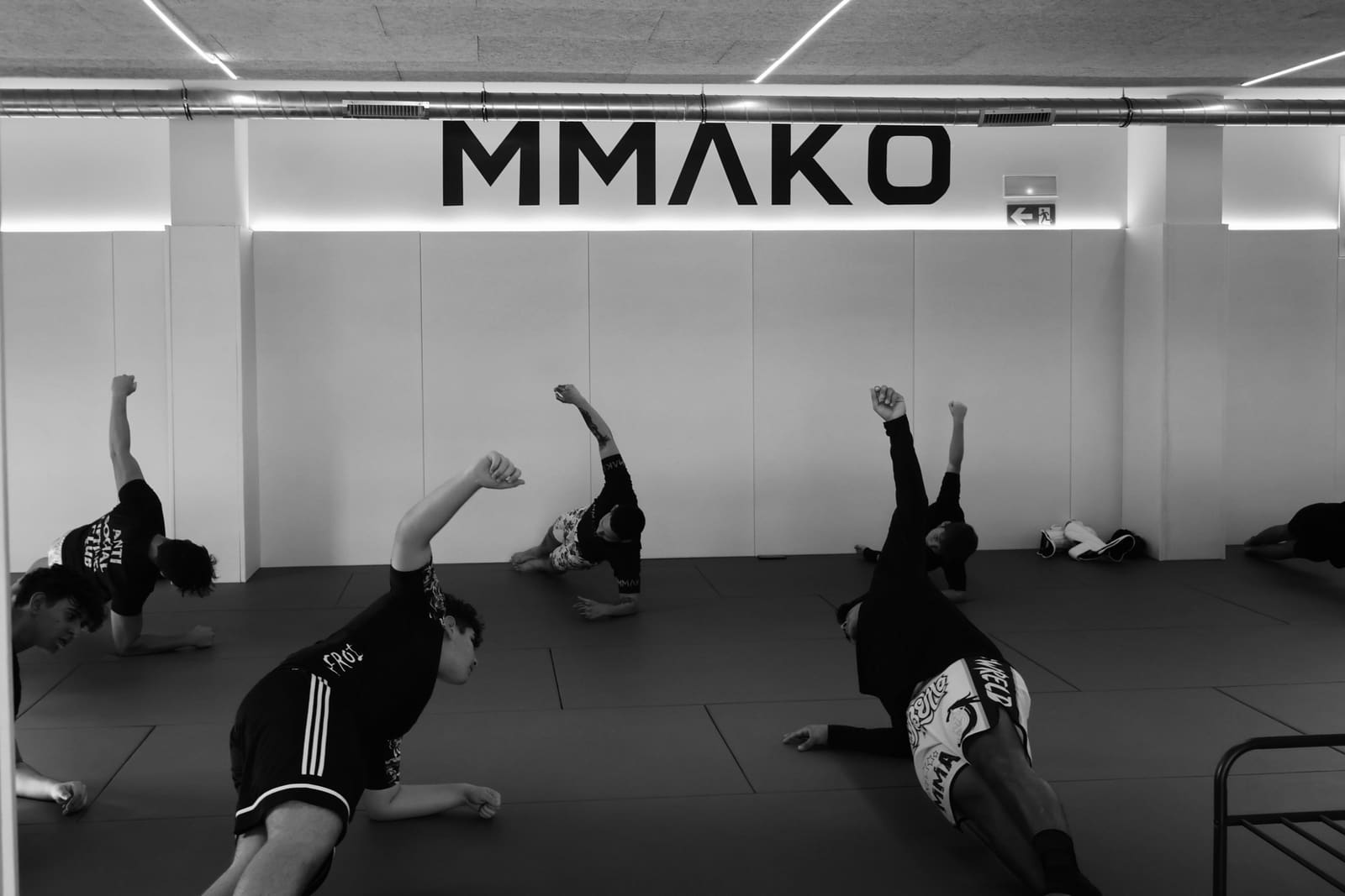 Alumnos haciendo ejercicios de calentamiento en el tatami