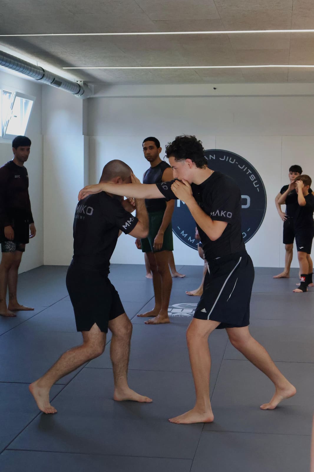 Dos alumnos practicando de pie durante una clase